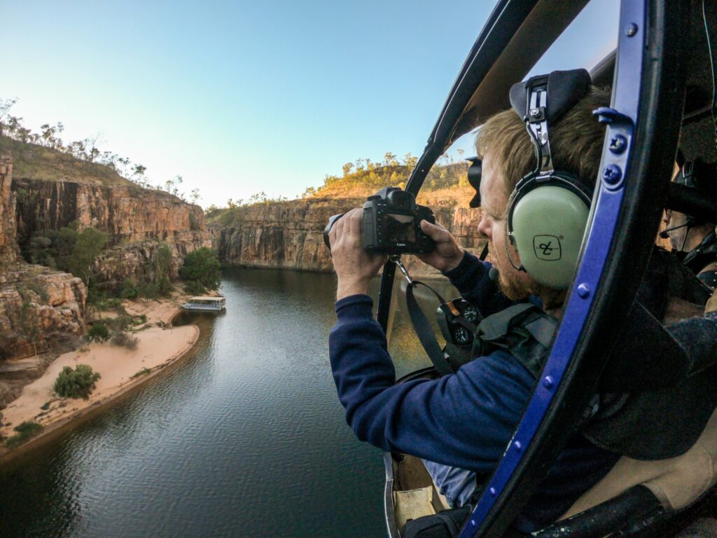 Man taking photo from helicopter, Nitmiluk Gorge, Northern Territory