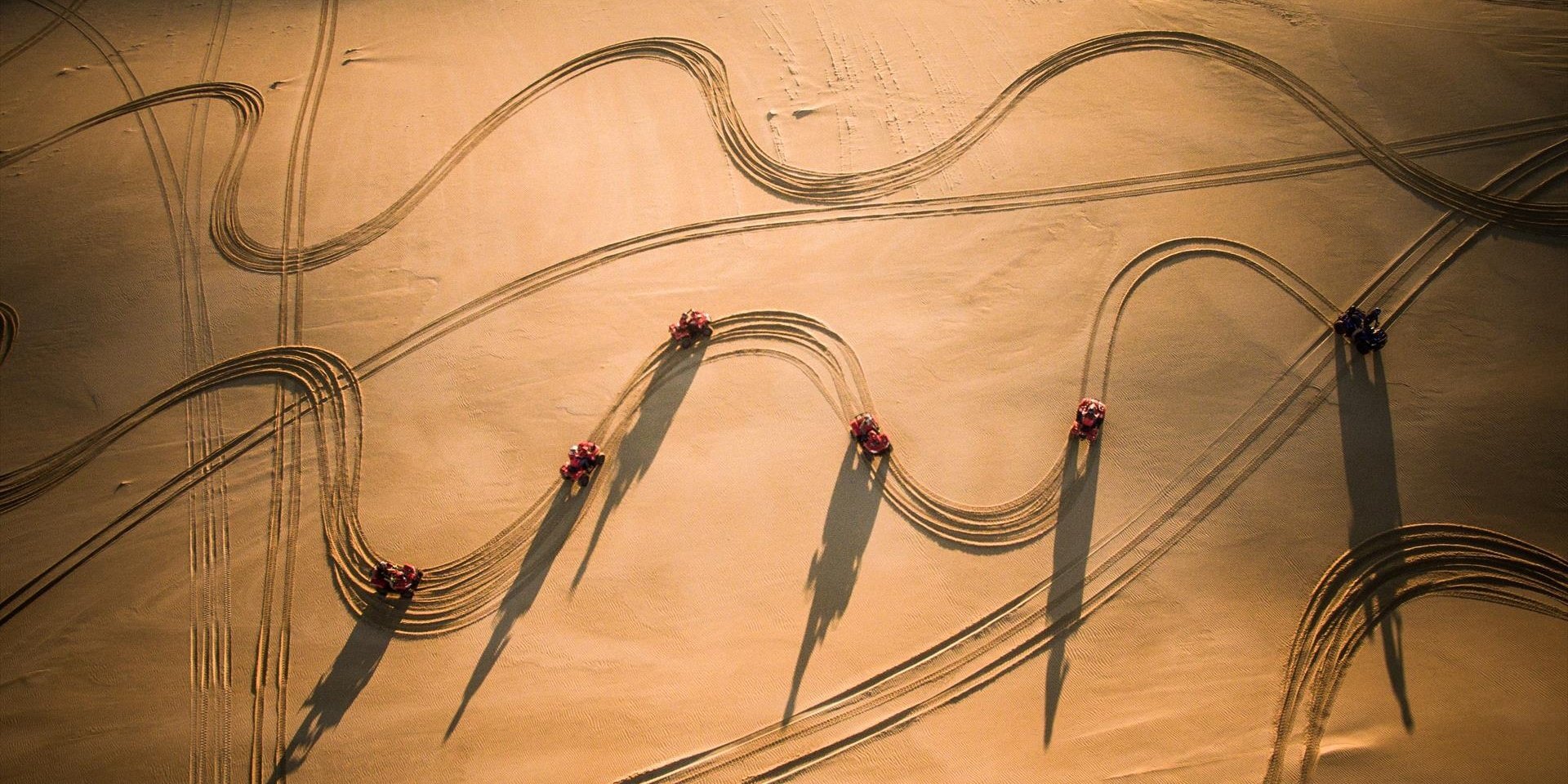 Aeriel shot of quad-bikes and tracks in sand dunes